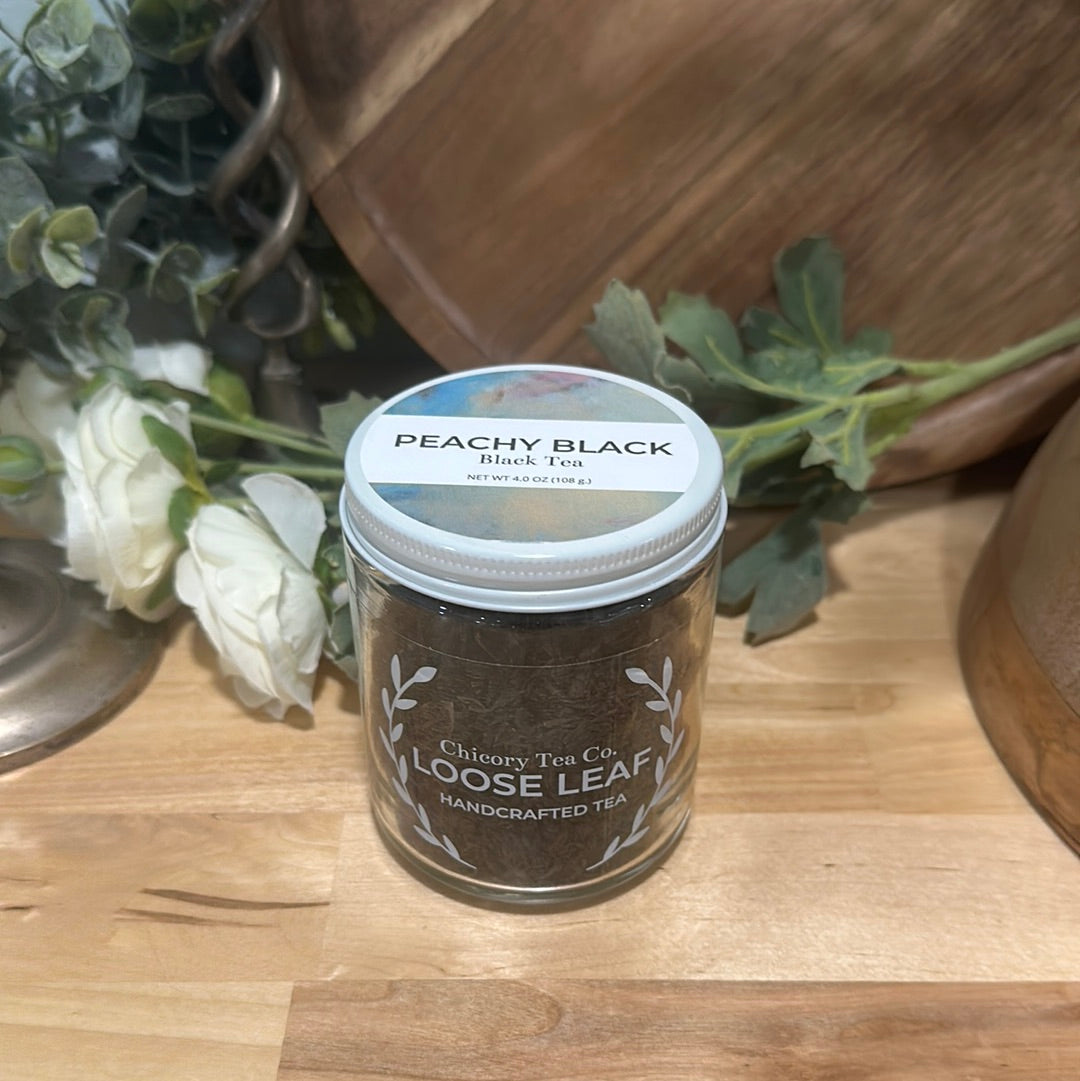 An artistic product photo of Chicroy Tea Co.'s Peachy Black Tea in the jar, view from front