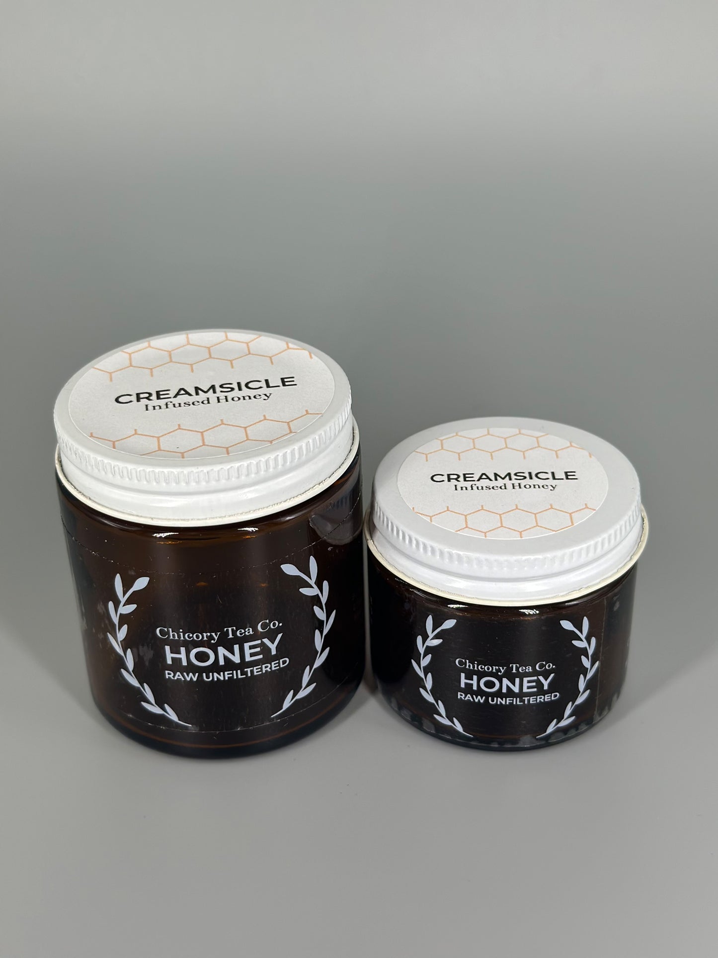 Chicory Tea Co.'s Creamsicle Honey in 2oz and 4oz jars, view from the front
